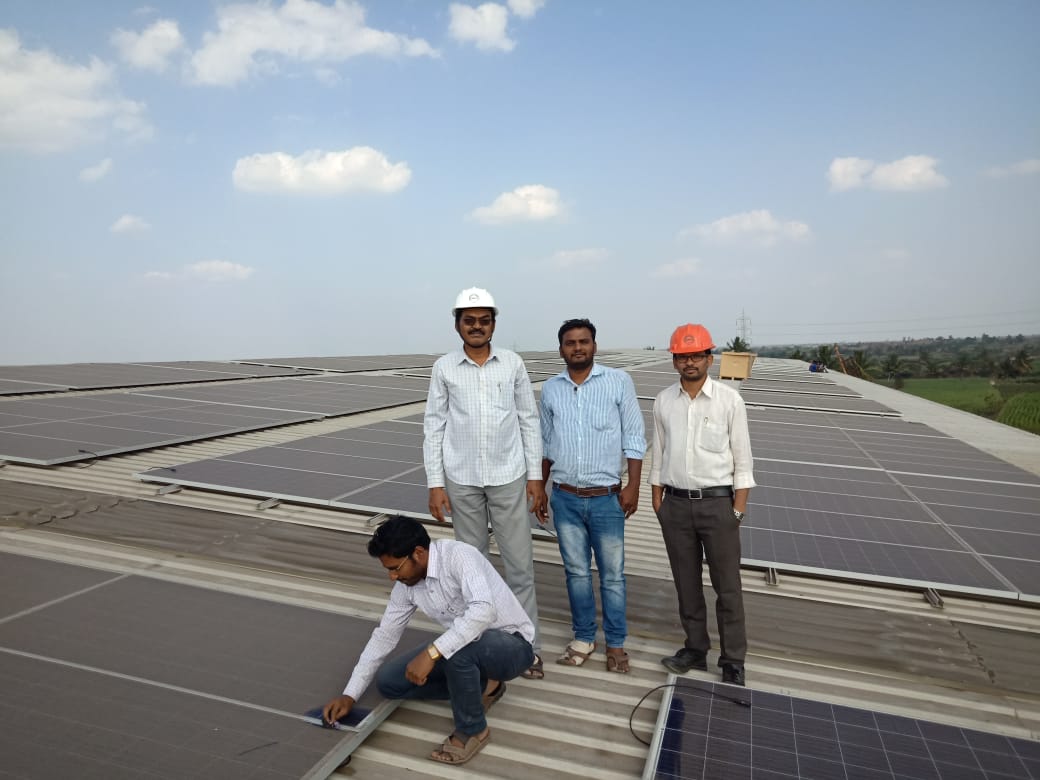 Green Tree team standing on a large industrial rooftop solar array