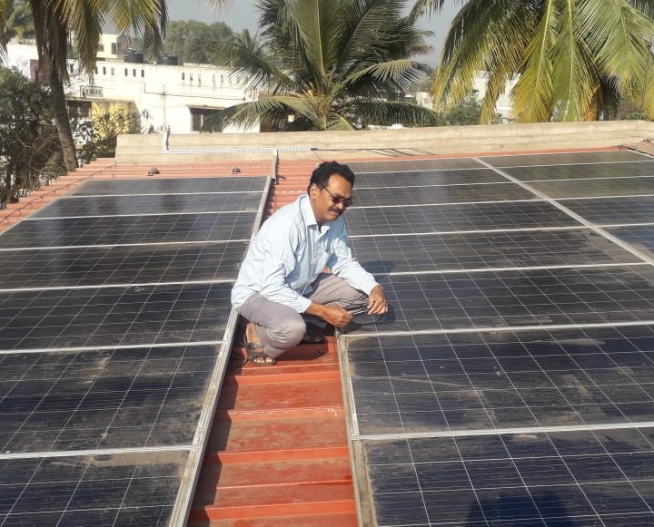 Green Tree technician inspecting rooftop solar panels on a home